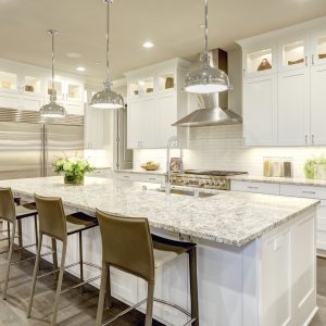 White kitchen design features large bar style kitchen island with granite countertop | Pierce Carpet Mill Outlet