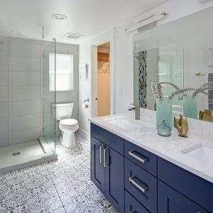 Modern bathroom interior with blue double vanity and glass shower | Pierce Carpet Mill Outlet
