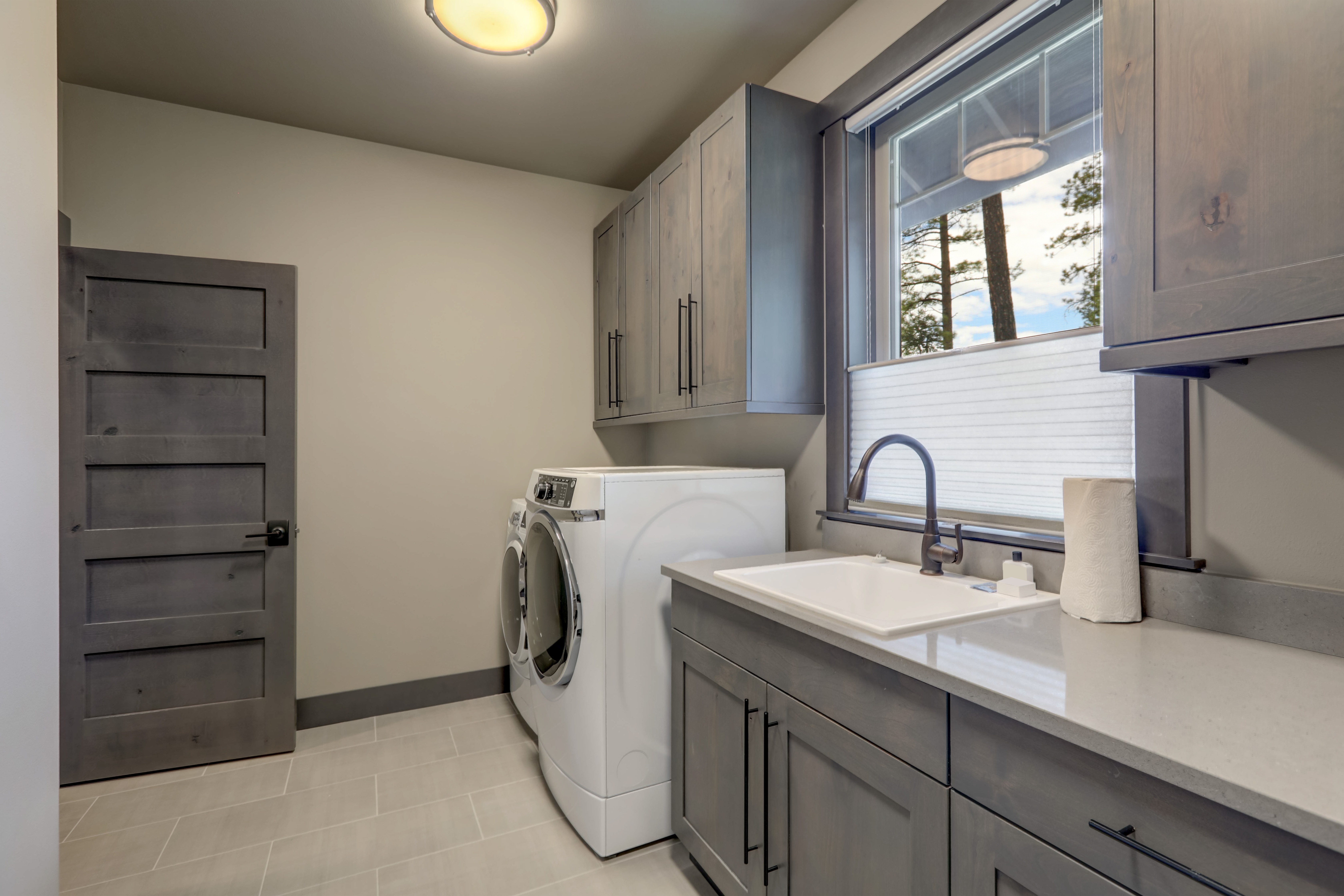 Beautiful laundry room with rish wooden doors and white washer and dryer | Pierce Carpet Mill Outlet